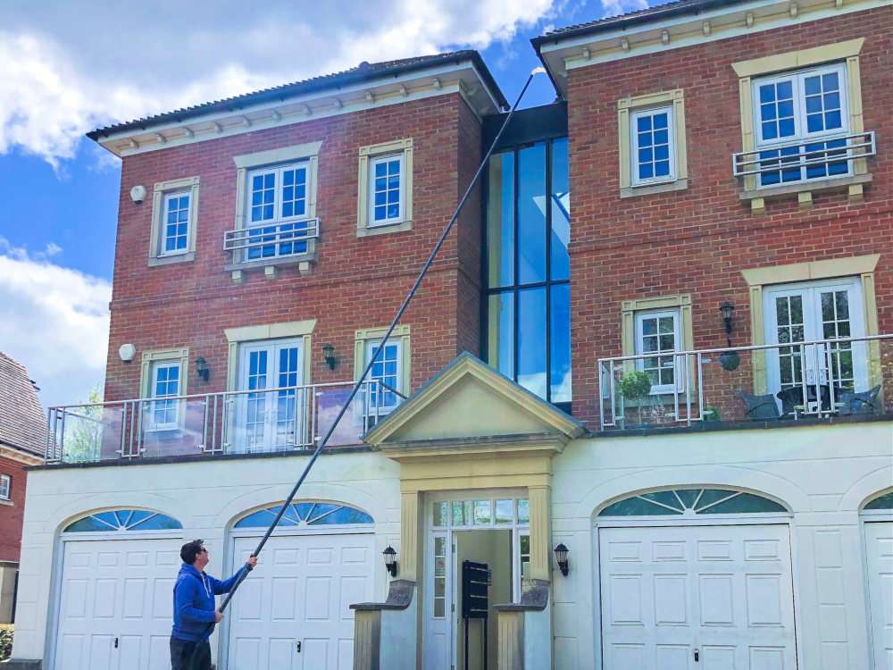 Stayclean operator clearing gutters with a long vacuum pole at a Bristol property